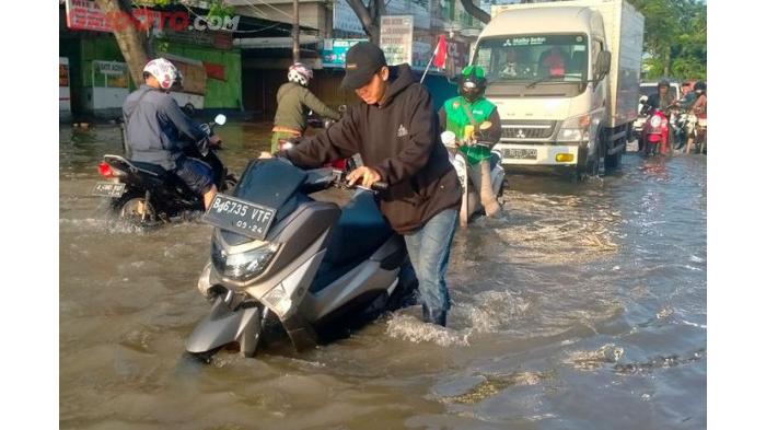 Ilustrasi Melewati Jalan yang Menggenang/ Perawatan Motor Listrik Saat Musim Hujan. (GridOto)