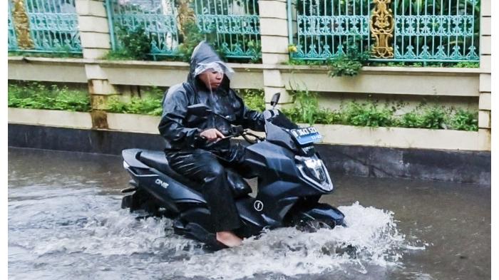 Ilustrasi Motor Listrik Melewati Jalan Banjir/ Perawatan Motor Listrik Saat Musim Hujan. (IwanBanaran)