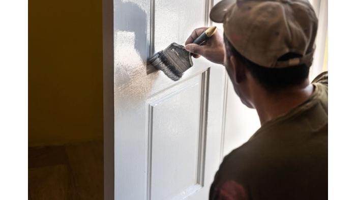 Ilustrasi mengaplikasikan cat pada pintu kayu agar lebih awet. (Shutterstock)