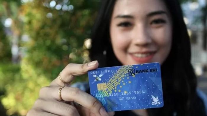 Ilustrasi seorang wanita memegang kartu ATM BRI Britama. (Tribunnews.com)