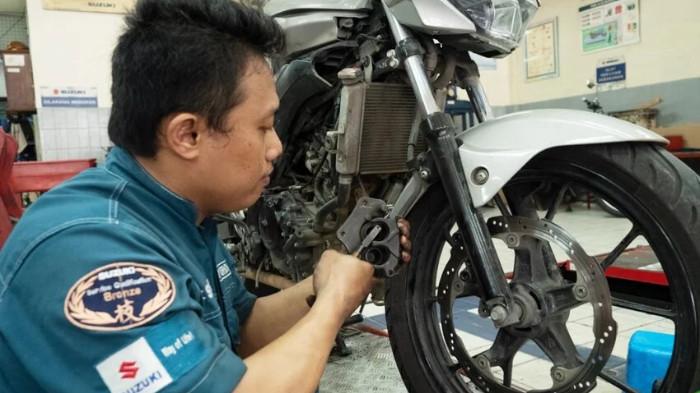 Ilustrasi Seorang sedang Memperbaiki Mesin Motor. (Suzuki Indonesia)