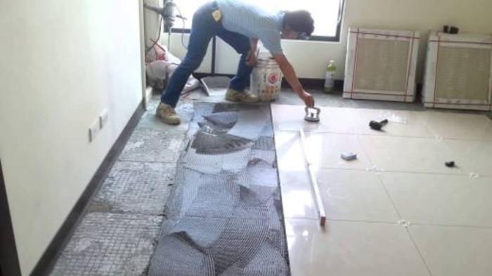 Ilustrasi Seseorang Sedang Melakukan Pemasangan Lantai Granit. (Granite Fix)