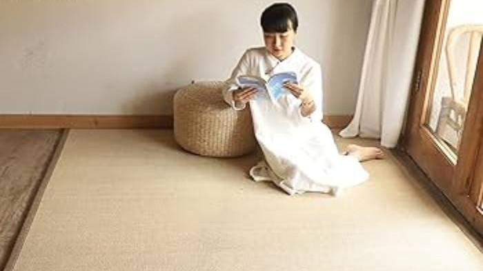 Ilustrasi Seseorang Sedang Membaca Buku Di Atas Karpet Bambu. (Amazon UK)