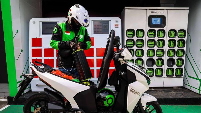 Ilustrasi Pengemudi Ojek sedang Mengisi Baterai Motor Listrik. (Kompas Otomotif)