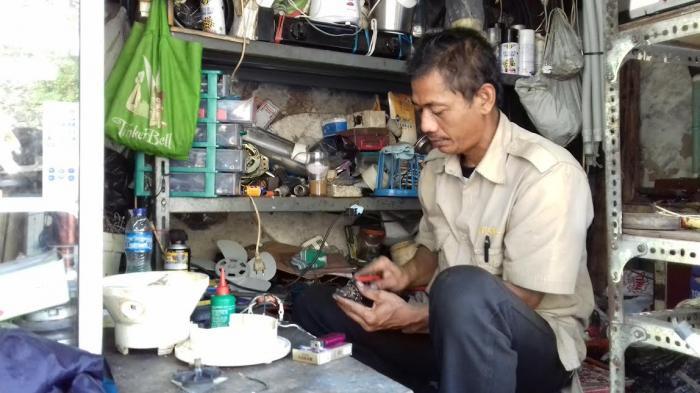 Ilustrasi Seorang Mekanik Elektronik sedang Memperbaiki Barang Elektronik. (Tribunnews.com)