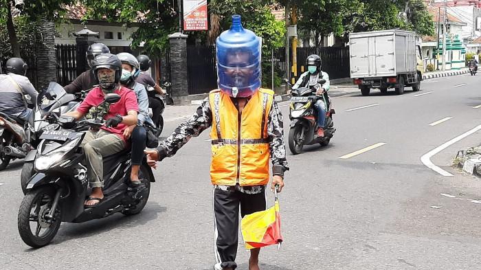 Pak Ogah sedang Mengatur Lalu Lintas. (Foto : Kompas Regional)