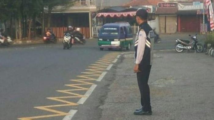 Petugas Dinas Perhubungan sedang Memantau Kondisi Lalu Lintas di Samping Marka Zig Zag Kuning. (Foto : Kompas Otomotif)