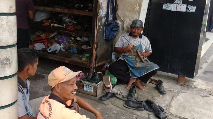 Tukang Sol Sepatu sedang Berdiskusi dengan Pelanggannya. (Foto : Kompas.com)