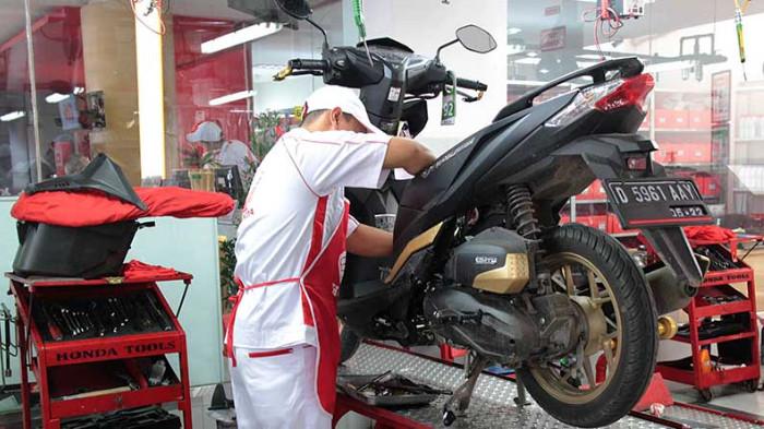 Ilustrasi mekanik sedang melakukan perawatan motor matic. (moladin.com)