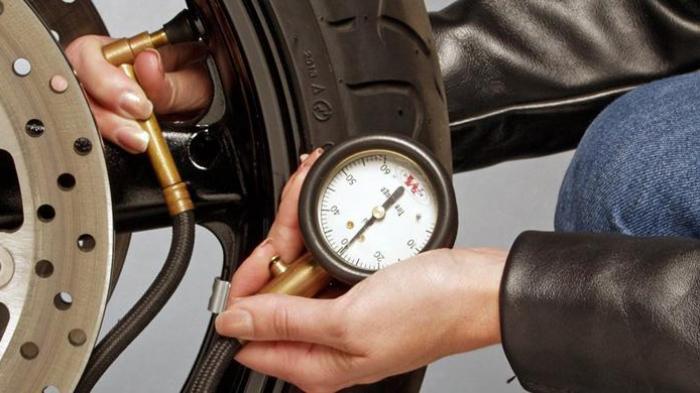 Ilustrasi mengecek tekanan angin pada ban motor. (tribunnews.com)