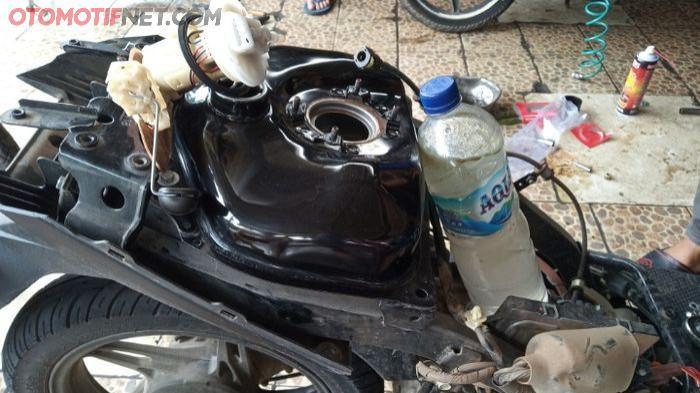 Ilustrasi tangki motor yang sedang dikeringkan guna membersihkan sisa air di dalam tangki. (gridoto.com)